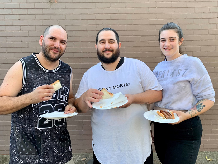 Participants enjoy a sausage sizzle at the Y Streetball four year celebration.
